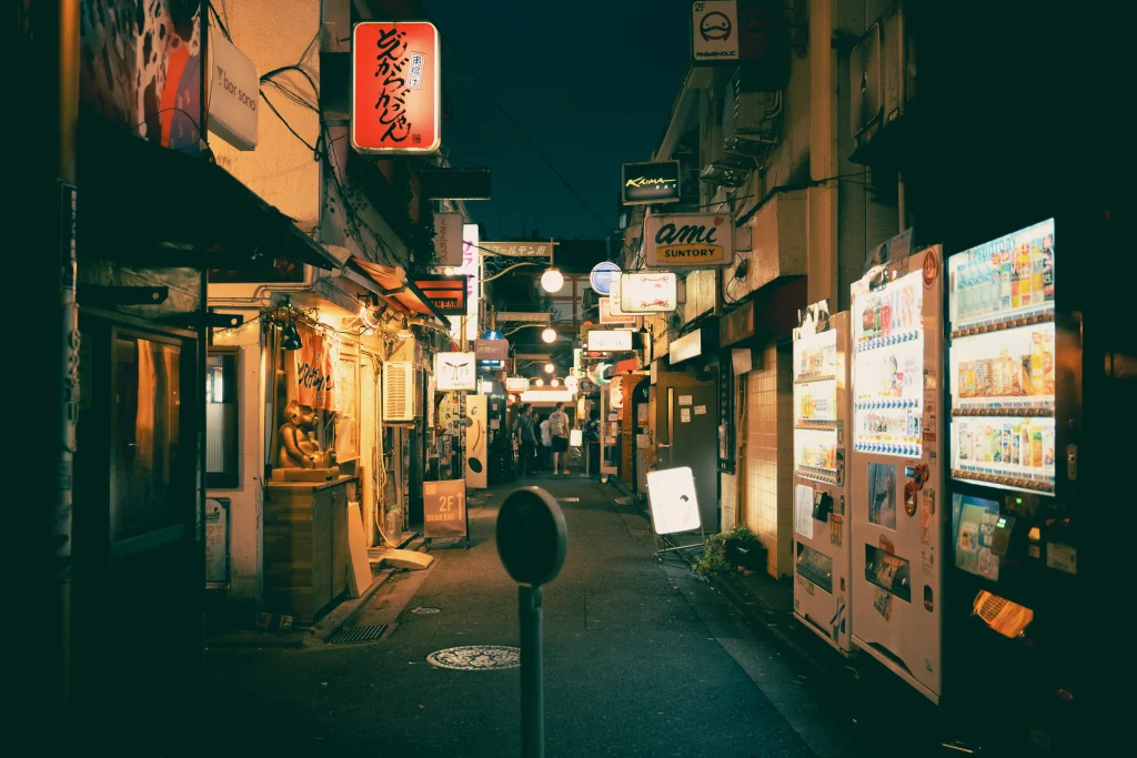 Narrow alley of Golden Gai filled with izakaya bars and locals enjoying nightlife in Shinjuku