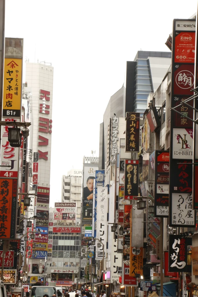 Busy Kabukicho street in Shinjuku with dense signs for bars, clubs, and entertainment venues